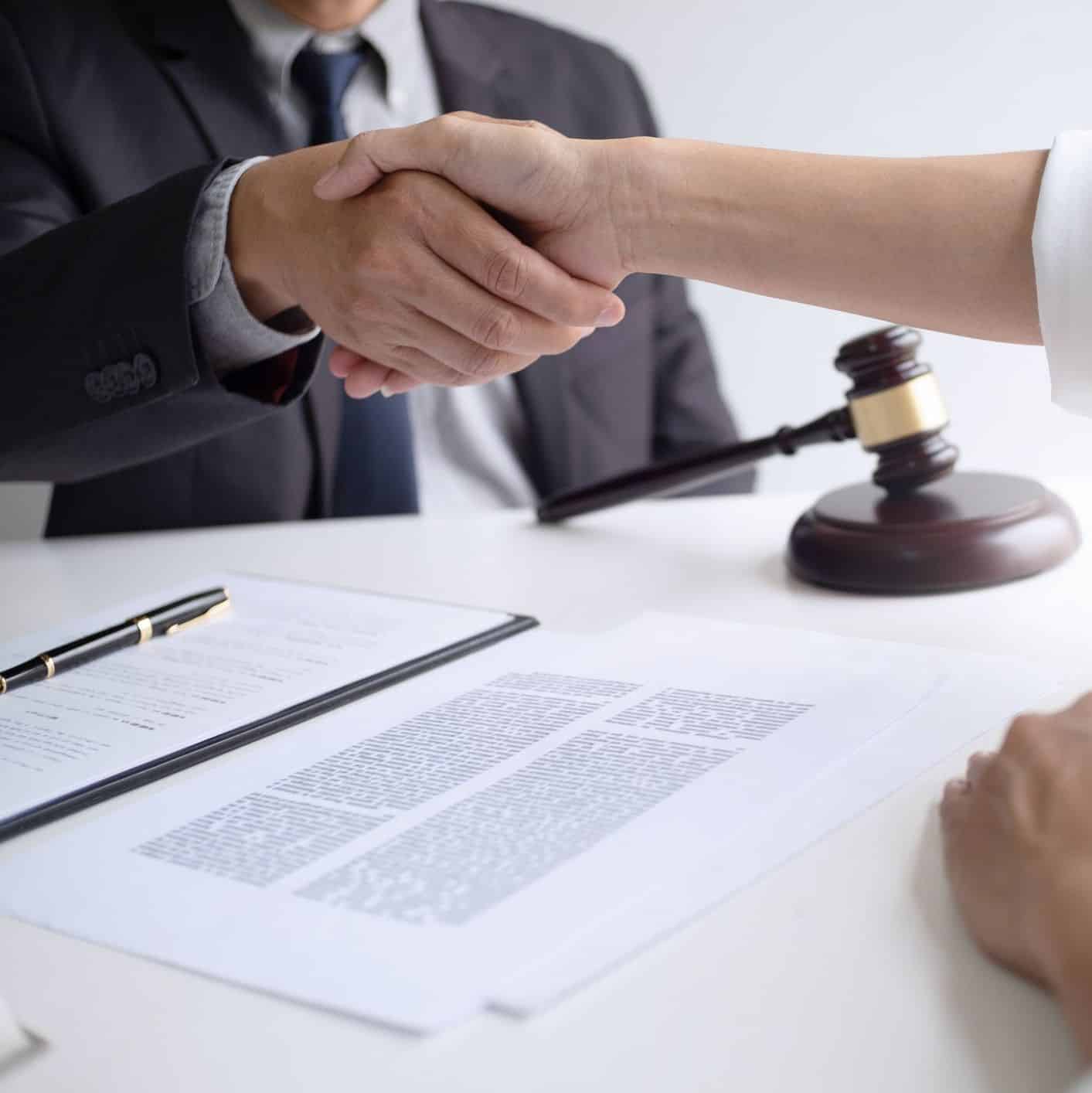 awyer with client hands shaking in courtroom, legal and justice concept.